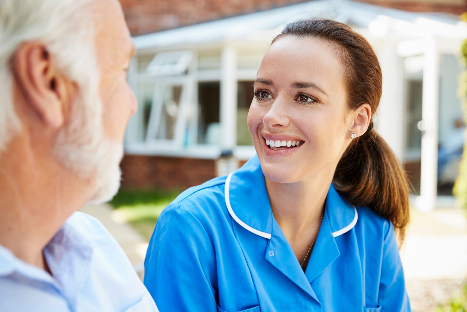 A senior man talking with a nurse on a bench